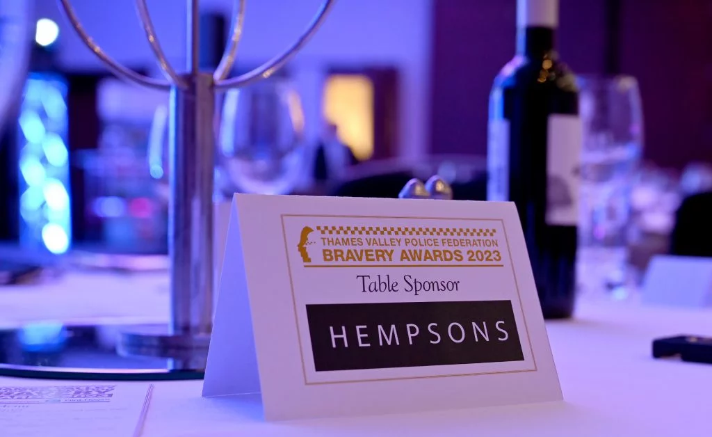 A sign on the table at Thames Valley Police Federation Bravery Awards 2023 announcing Hempsons as the table sponsor